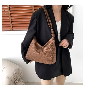 Détail d'un sac cabas marron caramel plissé présenté dans un cadre de vie décontracté