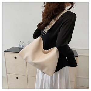 Detail of hobo bag with ethnic geometric strap and lychee grain leather texture