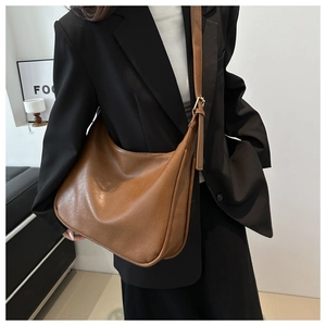 Nahaufnahme der braunen Kunstleder-Schultertasche mit feiner Textur und verstellbarem Riemen