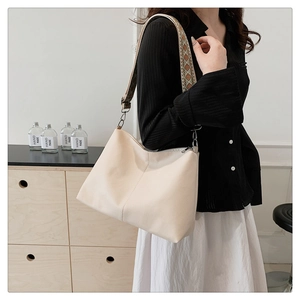 Detail of off-white lychee textured tote bag with ethnic geometric embroidered strap