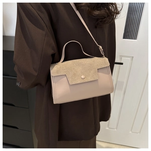 Fashionable beige crossbody bag shown on shoulder in a minimalist indoor setting