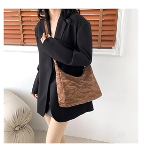 Vue détaillée du sac hobo marron montrant la texture plissée et le cuir synthétique