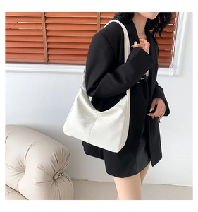 Sac porté épaule blanc en forme de croissant avec texture cuir porté par un modèle