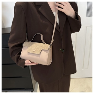 Frosted suede beige crossbody bag with top handle and metal buckle shown with a model