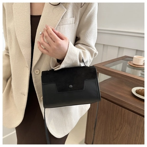 Detail of elegant black crossbody bag with mixed suede and smooth leather texture