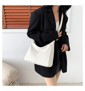 Gros plan du sac sous l'aisselle à motif marbre blanc avec large bandoulière sur modèle