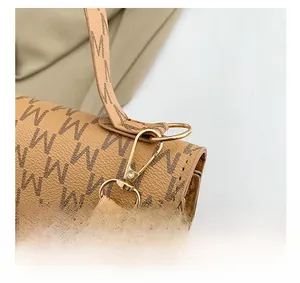 Detail of the golden lobster clasp and D-ring on the brown monogram leather crossbody bag
