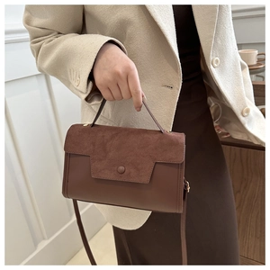 Detail of French minimalist brown patchwork handbag with suede and smooth leather texture