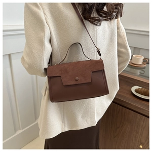 Brown leather handbag with suede flap and detachable strap shown on shoulder