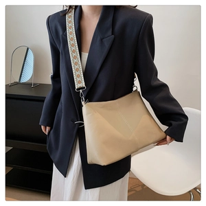 Retro beige bucket bag with ethnic woven strap and contrast stitching on grainy leather