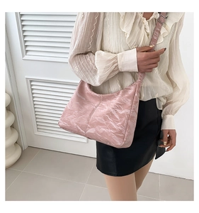 Détail du sac hobo rose avec texture plissée brillante et bandoulière réglable