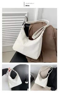 Détail d'un sac hobo blanc en similicuir froissé avec une bandoulière large et élégante