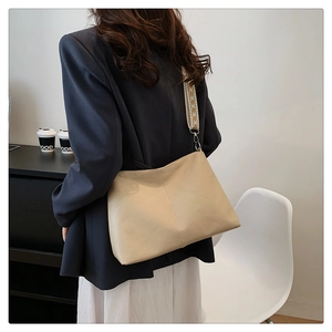 Detail of beige hobo bag showing litchi grain texture and ethnic geometric strap