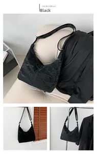 Détail du sac hobo noir avec une texture froissée brillante unique et une bandoulière assortie