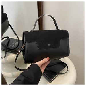 Detail of black faux suede and leather textures on the modern crossbody handbag