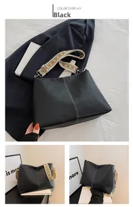 Detail of black pebbled leather bucket bag with colorful geometric jacquard wide strap