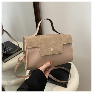 Close-up of frosted suede handbag with single handle and adjustable shoulder strap