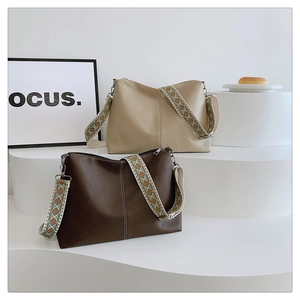 Detail of lychee-textured leather tote bags with geometric jacquard embroidery straps