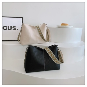 Close-up of vintage bucket bags with wide bohemian patterned straps in cream and black