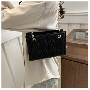 Elegant black matelassé shoulder bag with gold chain strap for women commuters