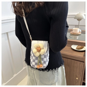Detail of a grey checkered bubble fabric crossbody phone bag with a large yellow daisy