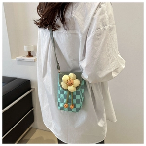 Detailed view of checkered crossbody phone bag with a large 3D yellow floral decoration