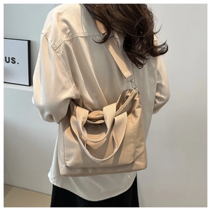 Versatile beige nylon bucket tote bag with adjustable shoulder strap and front pocket