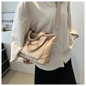 Detail of adjustable shoulder strap and canvas texture on the large capacity tote bag
