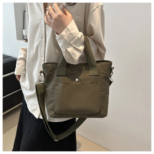 Detail of olive green canvas tote bag with adjustable strap and front snap pocket