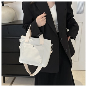 Minimalist beige nylon tote bag with front snap pocket and adjustable shoulder strap