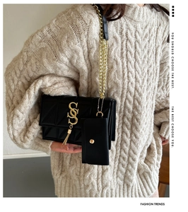 Détail du sac bandoulière matelassé noir avec pompon doré et mini pochette ronde