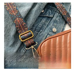 Detail showing adjustable embroidered colorful fabric strap on brown quilted PU leather bag