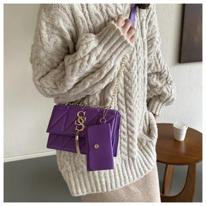 Détail d'un sac bandoulière matelassé violet avec chaîne dorée et élégant gland