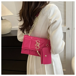 Detail of rose pink quilted chain bag with gold SSS buckle on a white textured blazer