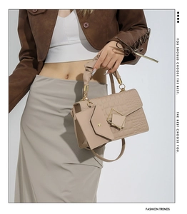 Detail of beige faux crocodile skin bag with ruched handle and golden geometric buckle