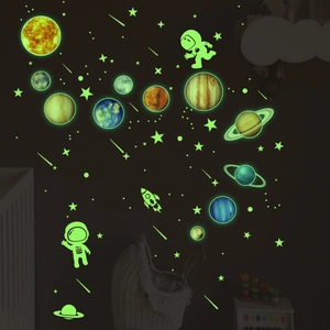 Luminous solar system wall stickers with astronauts and planets glowing in dark bedroom
