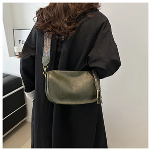 Détail du sac bandoulière vert olive avec bandoulière brodée bohème et crochets dorés