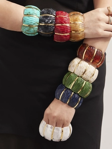 Close-up of wide stretch resin bangles with wavy textures and 18k gold plated accents