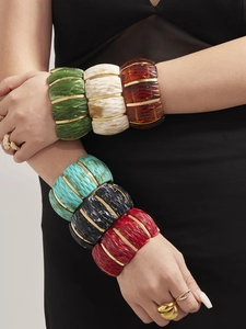 Close-up of colorful resin stretch bracelets with gold spacers in bohemian stacking style