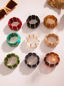 Macro detail of textured resin bangles with 18k gold plated links in nine vibrant colors