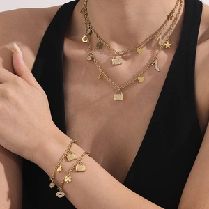 Layered 18k gold plated necklace and bracelet set with multi-element zirconia charms