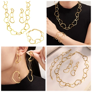 Detail view of a gold-plated stainless steel jewelry set with hollow heart designs