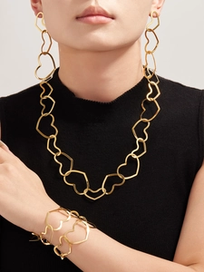 Model wearing gold hollow heart jewelry set featuring necklace earrings and bracelet