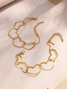 Detail view of gold stainless steel hollow heart chain necklace and bracelet with clasp
