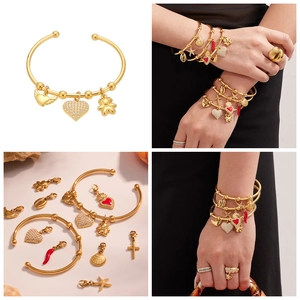 Détail d'un bracelet DIY plaqué or 18k avec breloques cœur en zircon et croix en acier