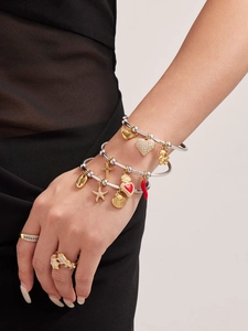 Détail macro de bracelets multicouches avec pendentifs en or 18 carats et breloques