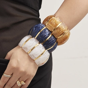 Stackable wide resin bangles in marble white, blue, and amber with gold stainless steel trim