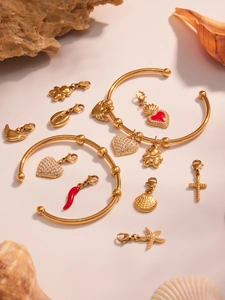 Détail de bracelets plaqués or 18 carats avec breloques en émail et pendentifs en zircon
