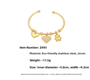 Détail d'un bracelet jonc en acier plaqué or 18 carats avec breloques cœur et ours