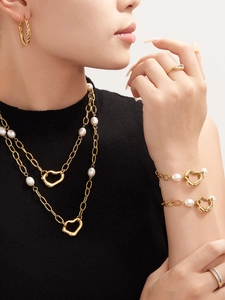 Detail of 18k gold plated necklace and bracelet set with irregular hearts and pearls